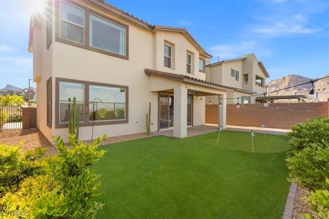 Rear view of house featuring stucco siding, a fenced backyard, a mountain view, and a tile roof | Image 48
