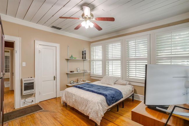 Bedroom with heating unit, crown molding, wood finished floors, a ceiling fan, and wooden ceiling | Image 32