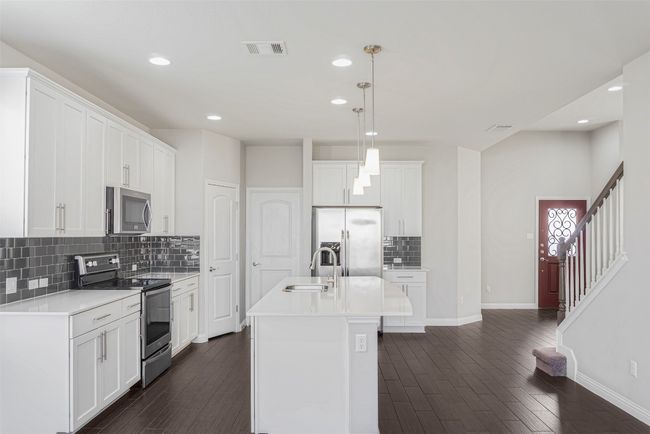 Kitchen featuring appliances with stainless steel finishes, tasteful backsplash, recessed lighting, dark wood-style floors, and light countertops | Image 14