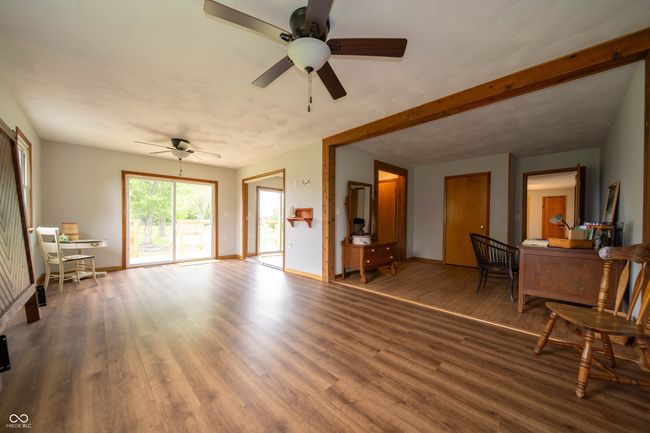 living area featuring wood finished floors, ceiling fan, and baseboards | Image 22
