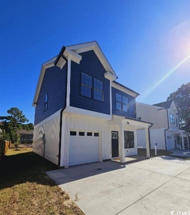 View of front of home featuring a garage, concrete driveway, and board and batten siding | Image 21