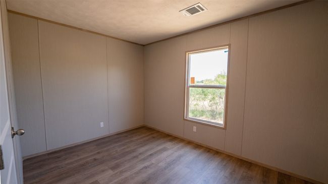 Spare room featuring wood finished floors, a decorative wall, and ornamental molding | Image 14