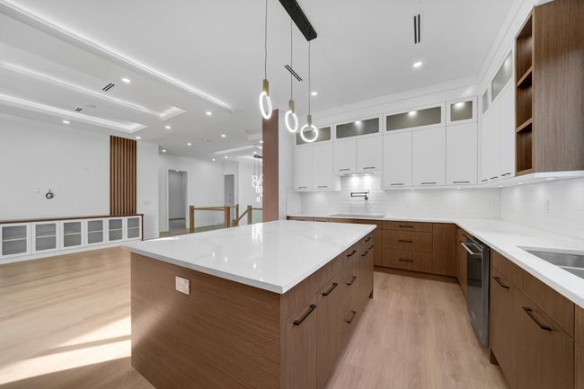 Kitchen with light wood-type flooring, a center island, decorative backsplash, stainless steel dishwasher, and recessed lighting | Image 5