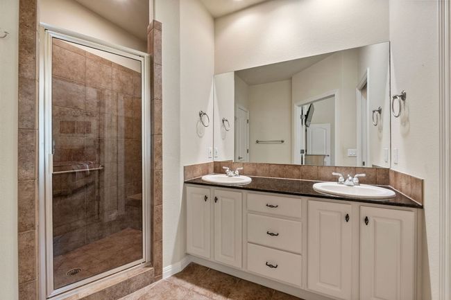 Full bath featuring a shower stall, double vanity, and tile patterned floors | Image 27