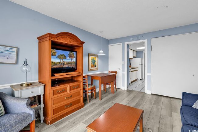 Living room featuring light wood-type flooring and baseboards | Image 6