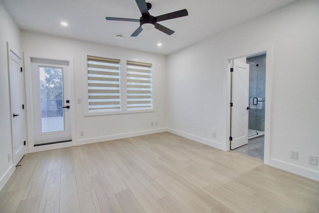 Empty room with light wood-style floors, ceiling fan, recessed lighting, and baseboards | Image 12