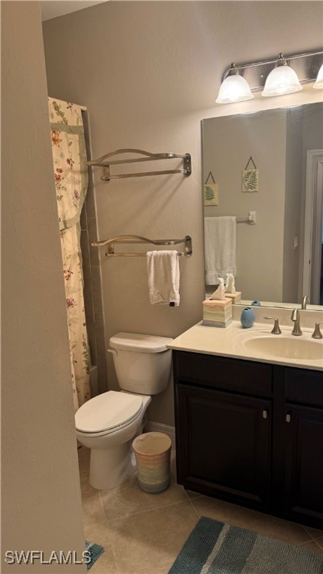 Full bath with tile patterned floors, vanity, and a shower with curtain | Image 10