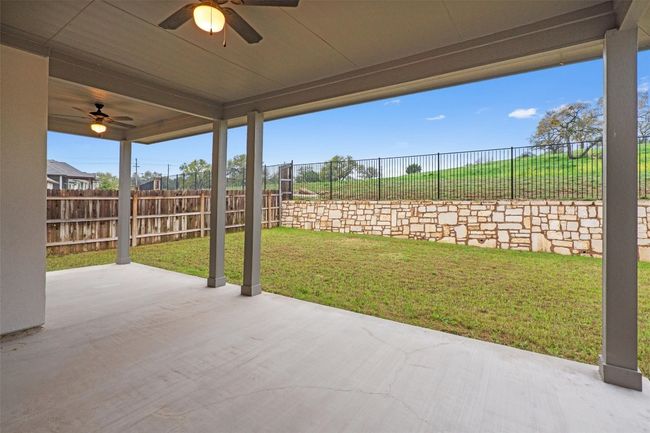 View of patio featuring a fenced backyard and ceiling fan | Image 35