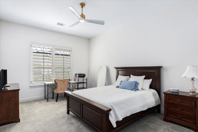 Bedroom featuring light carpet, baseboards, and ceiling fan | Image 21