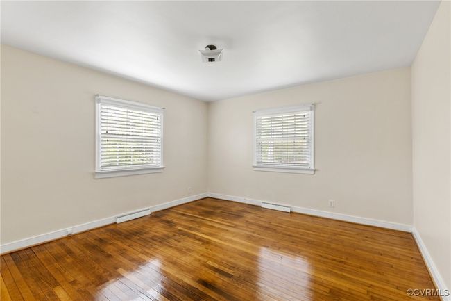 Spare room featuring visible vents, a baseboard radiator, hardwood / wood-style flooring, and baseboards | Image 18