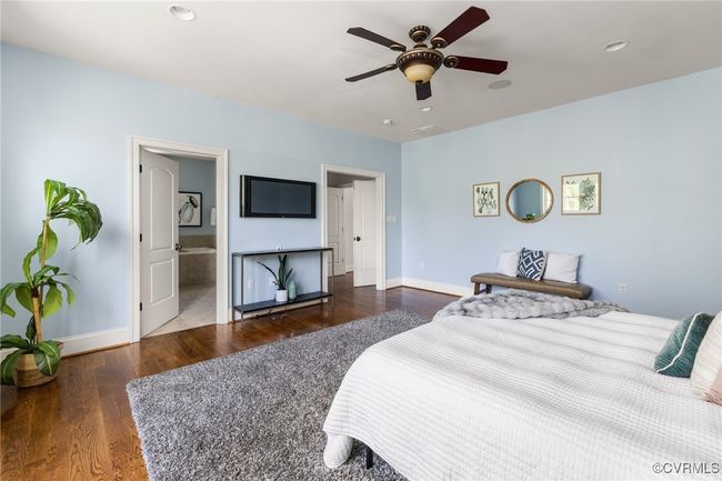 2nd floor primary suite, french doors to vesitbule, site finished hardwood floors, juliet balcony, surround sound, recessed lighting, ceiling fan with light; access to en suite and custom closet. | Image 24