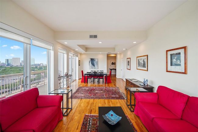 Spacious open-plan living and dining area with stunning city views. | Image 9
