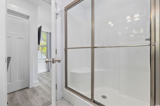 Bathroom with baseboards, wood finished floors, and a shower with shower door | Image 33