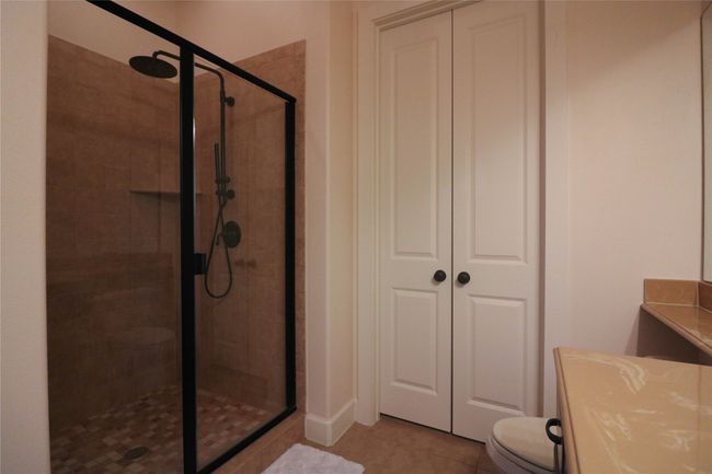 Bathroom with toilet, a stall shower, vanity, and tile patterned flooring | Image 26