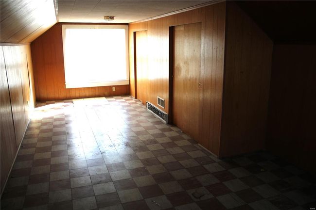Additional living space featuring lofted ceiling, visible vents, and wooden walls | Image 12