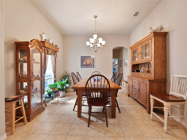 Dining space featuring arched walkways, a chandelier, light tile patterned floors, and baseboards | Image 5