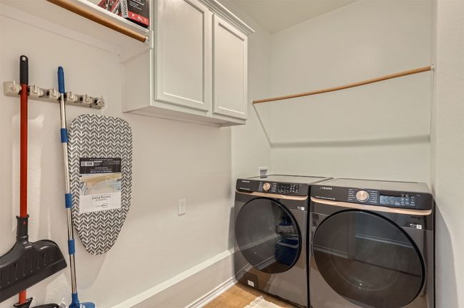 Laundry room featuring cabinet space, washer and dryer, and light wood-style floors | Image 23
