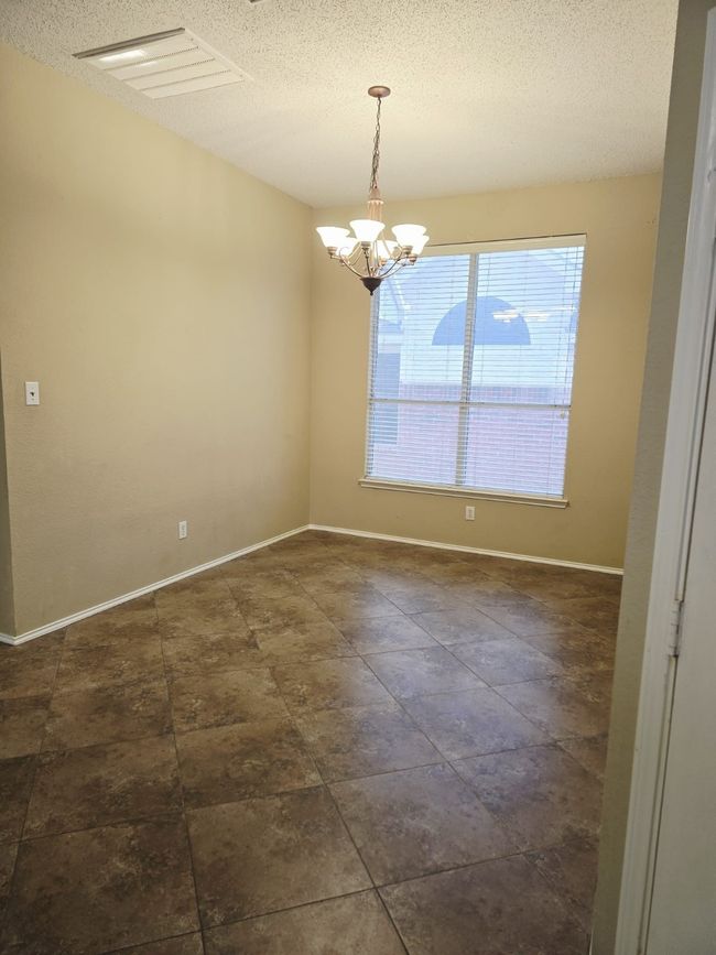 Empty room featuring a chandelier, a textured ceiling, and baseboards | Image 17