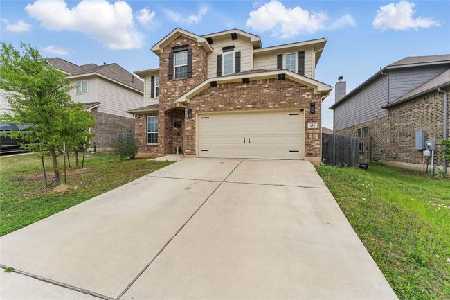 Traditional-style house featuring a garage, fence, concrete driveway, brick siding, and a front lawn | Image 40
