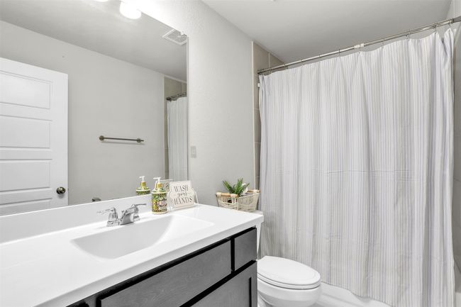Bathroom with vanity, curtained shower, toilet, and visible vents | Image 20