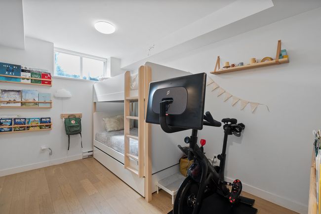 Exercise area with wood finished floors, a baseboard heating unit, and baseboards | Image 21