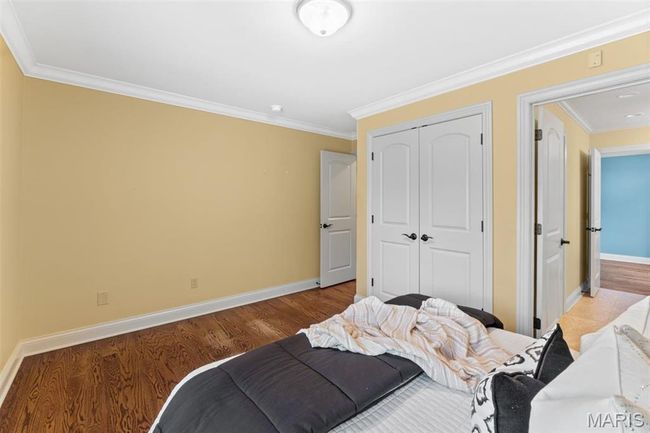 Bedroom featuring crown molding, a closet, and light wood-style flooring | Image 32