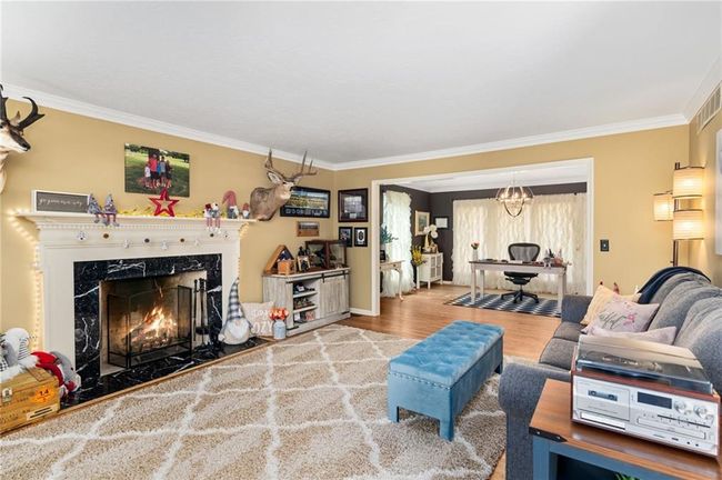 Living room featuring hardwood / wood-style flooring, crown molding, and a fireplace | Image 7