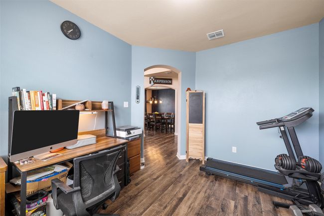 Home office with arched walkways and dark wood-style flooring | Image 12