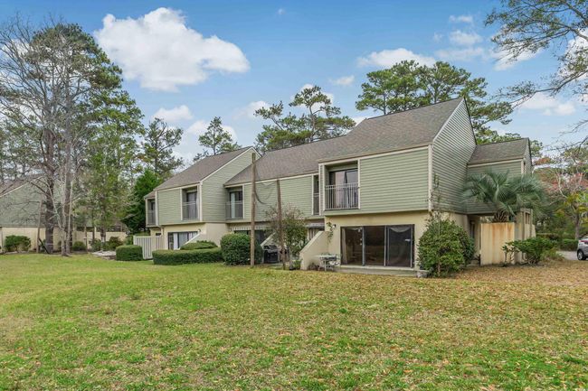 Rear view of property featuring a lawn, stucco siding, and roof with shingles | Image 28
