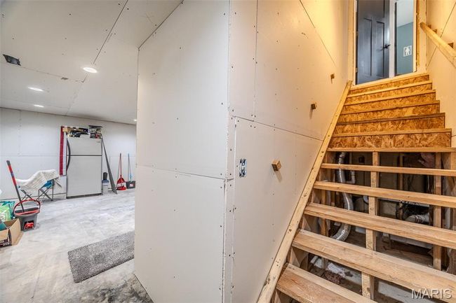 Staircase featuring unfinished concrete flooring and recessed lighting | Image 47