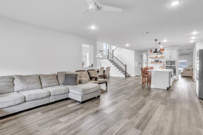 Living room with sink, ceiling fan with notable chandelier, and light hardwood / wood-style flooring | Image 8
