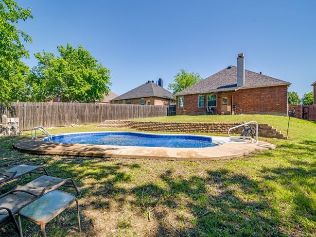 View of pool featuring a fenced backyard, a fenced in pool, and a lawn | Image 23