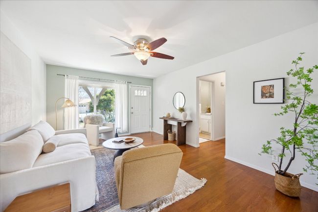 Living area with baseboards, a ceiling fan, and wood finished floors | Image 6