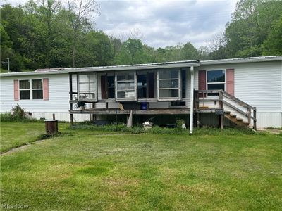 Manufactured / mobile home featuring a front lawn and a wooden deck | Image 1