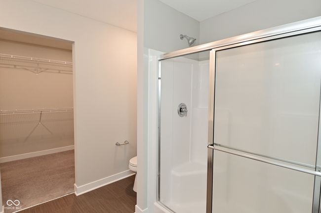 bathroom with a spacious closet, toilet, and a stall shower | Image 45