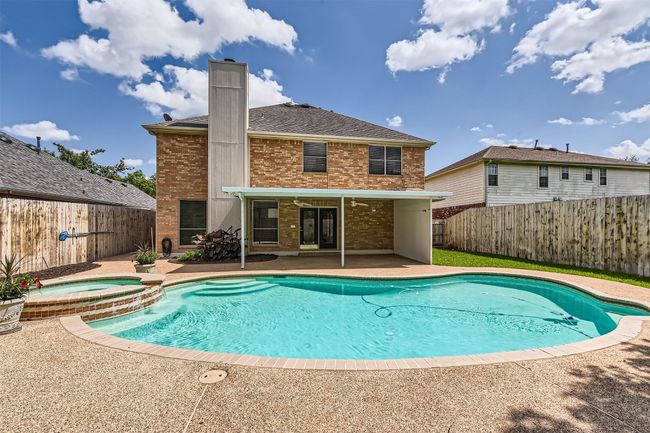 View of pool featuring a patio, a fenced backyard, and a pool with connected hot tub | Image 40
