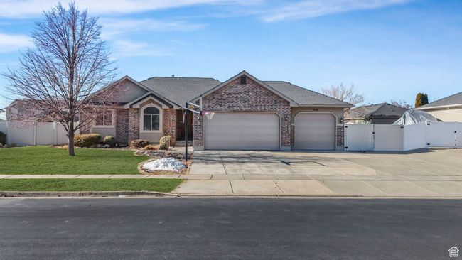 Ranch-style home with fence, brick siding, a gate, and an attached garage | Image 27