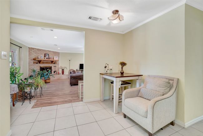 Sitting room featuring a fireplace, baseboards, crown molding, tile patterned flooring, and recessed lighting | Image 24