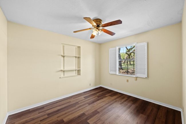 Bedroom with LVP finished floors, baseboards, and a ceiling fan | Image 21