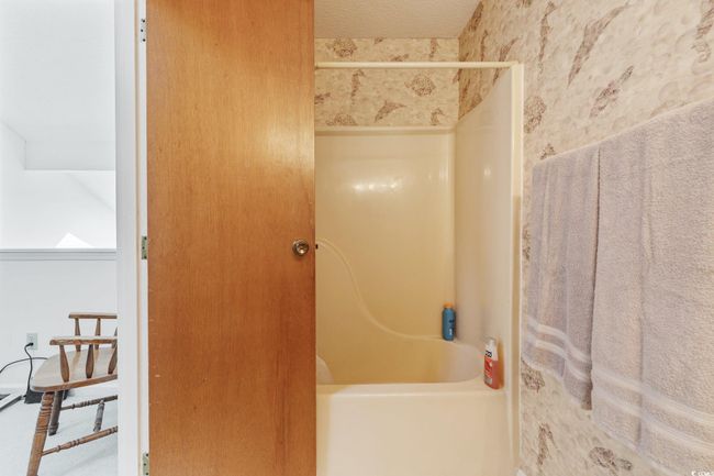 Bathroom featuring wallpapered walls and tub / shower combination | Image 16