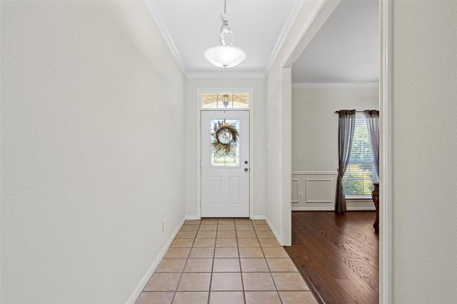 Foyer with light tile patterned floors, baseboards, and ornamental molding | Image 4