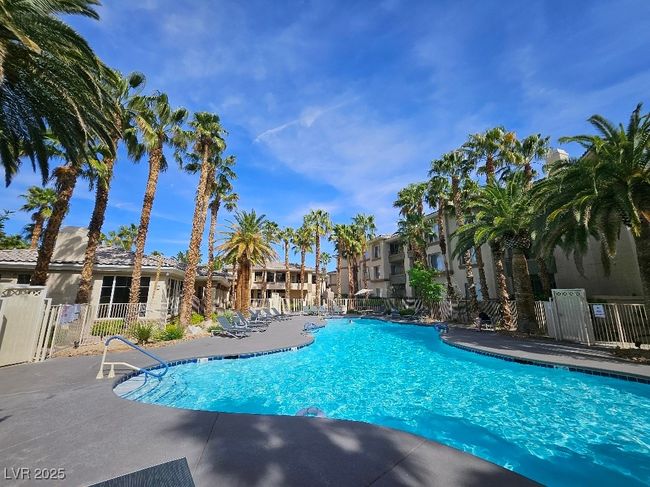 Community pool with fence, a patio area, and a residential view | Image 6