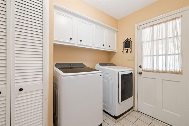 This indoor laundry room has a spacious closet and built-in cabinets for extra storage. | Image 22