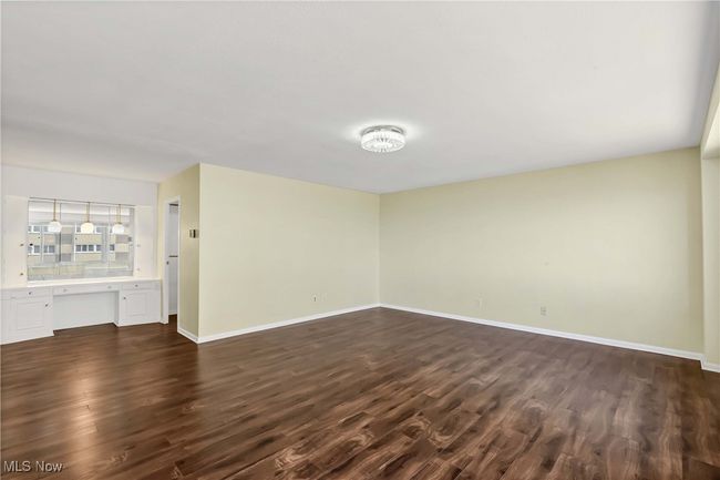 Spare room with baseboards, dark wood finished floors, and built in study area | Image 24