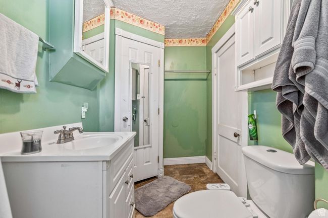 Bathroom with vanity, toilet, and a textured ceiling | Image 17