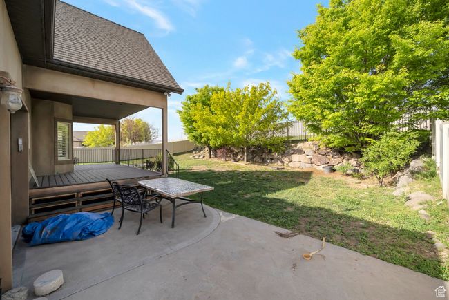 View of patio with a deck, outdoor dining area, and a fenced backyard | Image 45