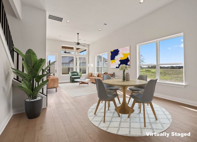 Dining room featuring a ceiling fan, visible vents, wood finished floors, and baseboards | Image 6