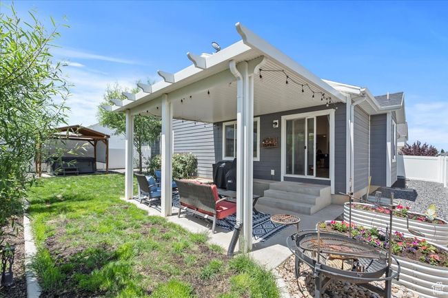 Rear view of house featuring a gazebo, a patio area, an outdoor fire pit, and entry steps | Image 29