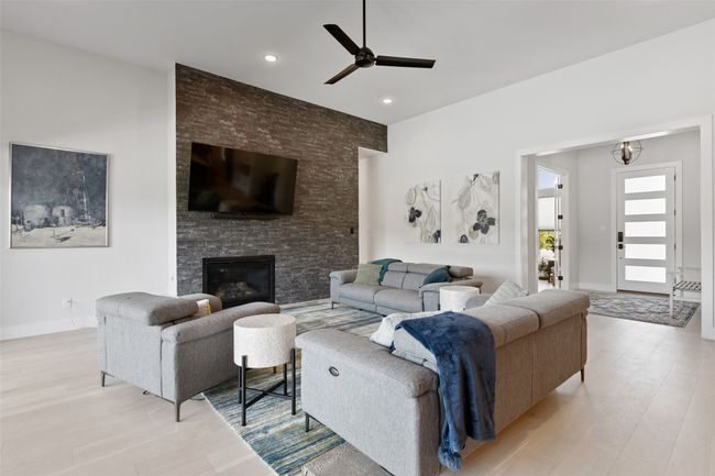 Living area with baseboards, light wood-style flooring, recessed lighting, a fireplace, and ceiling fan | Image 14
