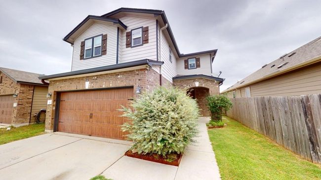 View of front of house with brick siding, fence, driveway, and a garage | Image 39